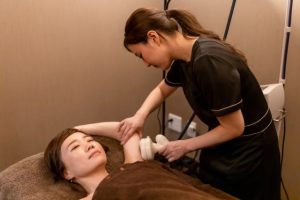Beauty Salon Lilyで女性が二の腕のエステ施術を受けている様子