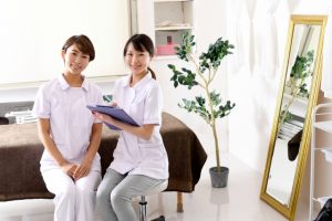 Beauty Salon Lilyの制服を着た2人の女性スタッフが笑顔でカウンセリングする様子