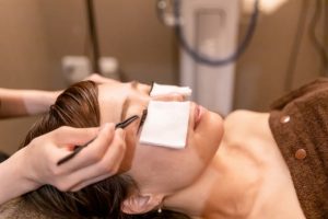 Beauty Salon Lilyでまつ毛エクステの施術を受ける女性、目元には白いパッド