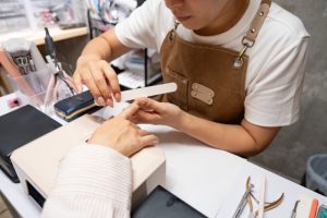 Beauty Salon Lilyでネイリストがお客様の爪をやすりで整えるネイルケア風景