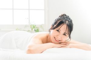 Beauty Salon Lilyのエステでうつ伏せになり笑顔でカメラを見る女性